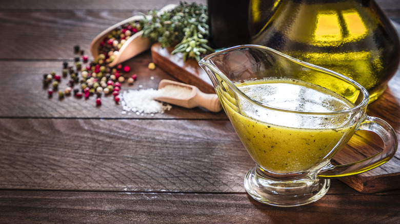 Vinaigrette in gravy boat with herbs