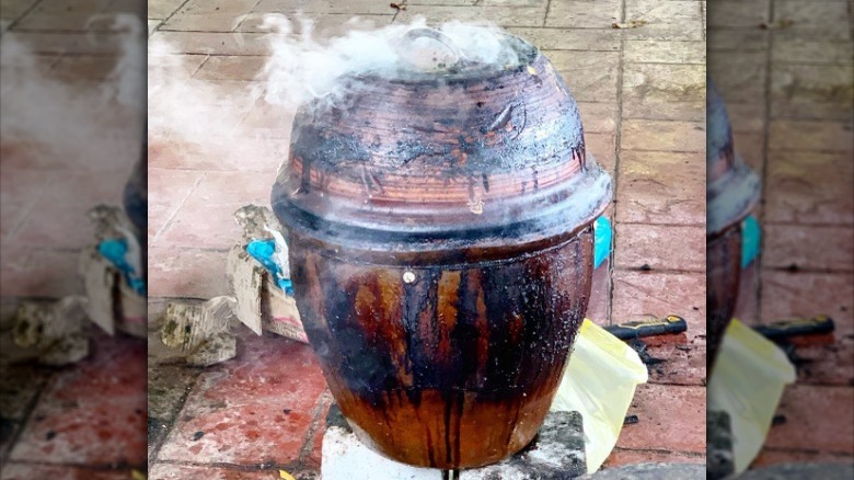 Close up of clay pot vessels roasting chicken