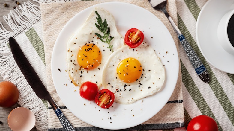 sunny side up eggs on plate with tomatoes