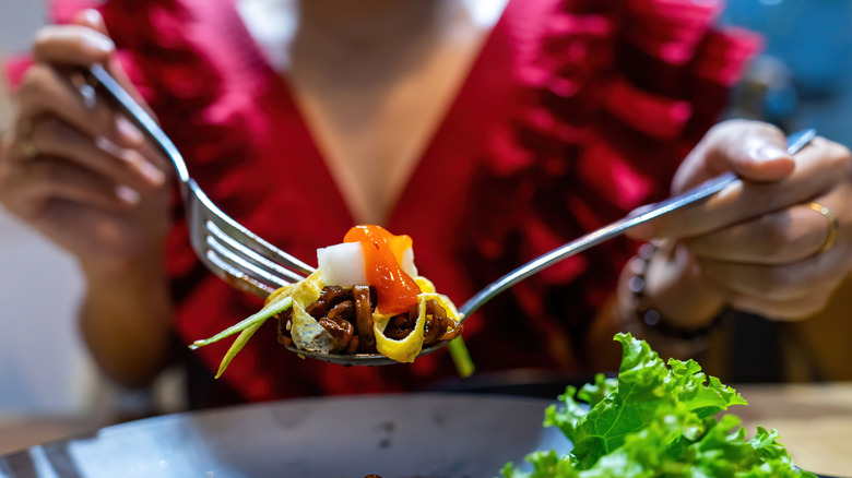 egg noodles with beef held by a fork