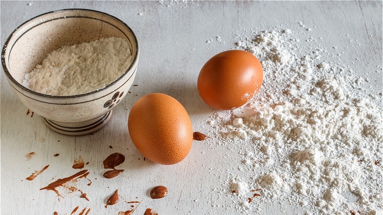 Two intact eggs on sprinkled flour 