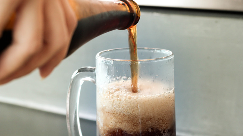 Pouring root beer into a glass