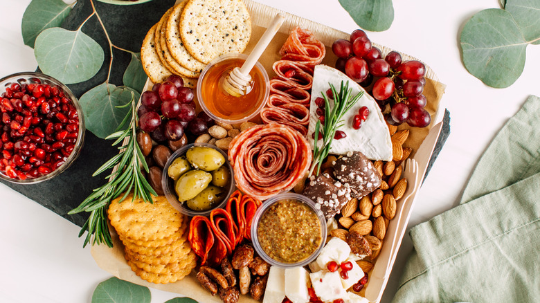 Charcuterie board surrounded by leaves