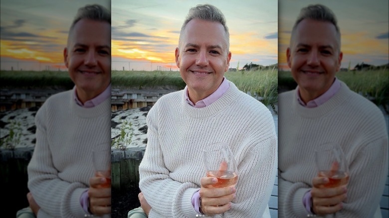 Ross Mathews posing outside with wineglass