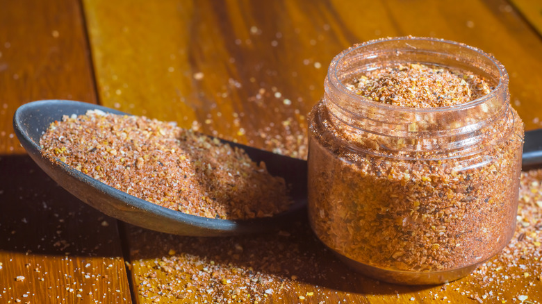 Spoon next to a jar of dry spice rub