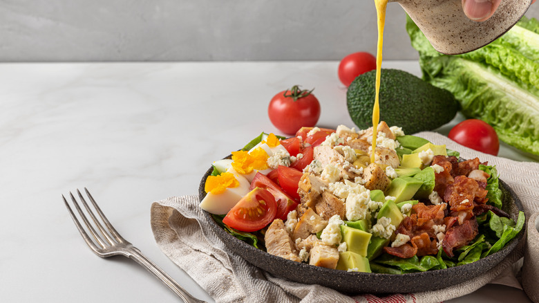 pouring dressing over salad