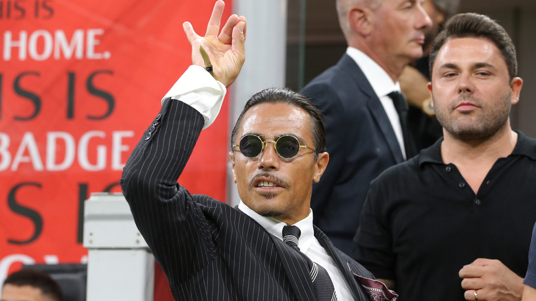 Salt Bae holding the World Cup trophy.