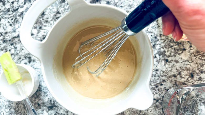 hand stirring khaki-colored substance