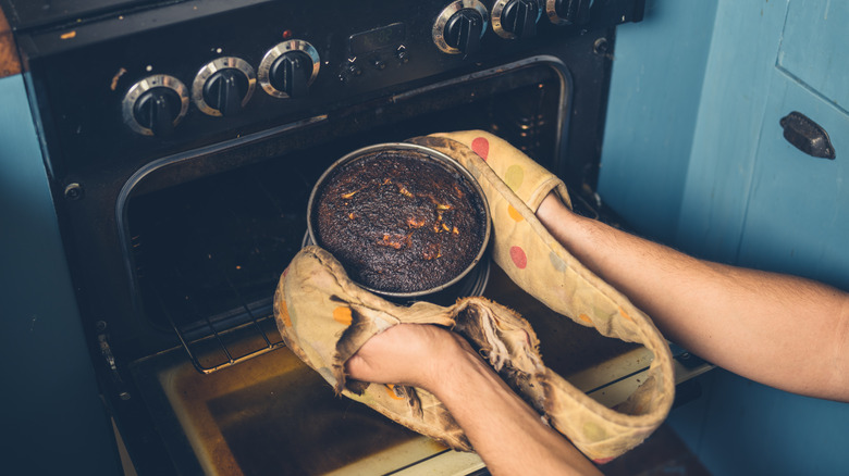 person pulls dish from oven