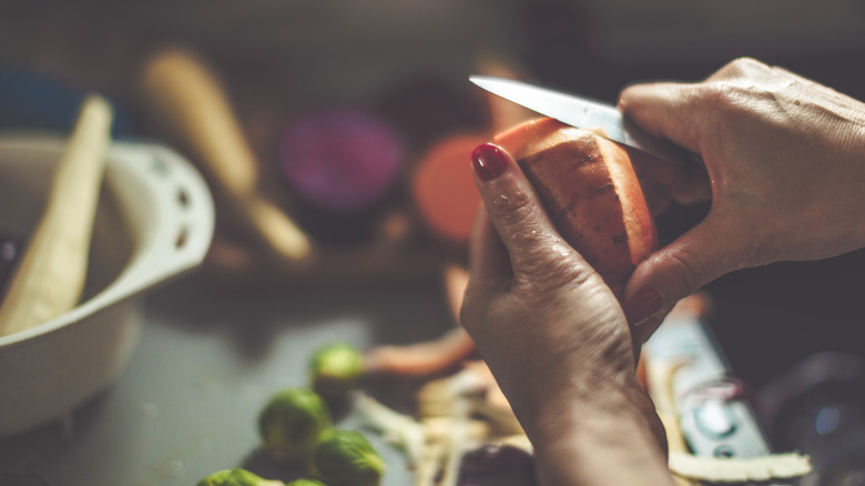 Person peeling sweet potato