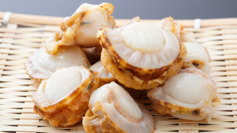 pile of steamed scallops on a bamboo mat