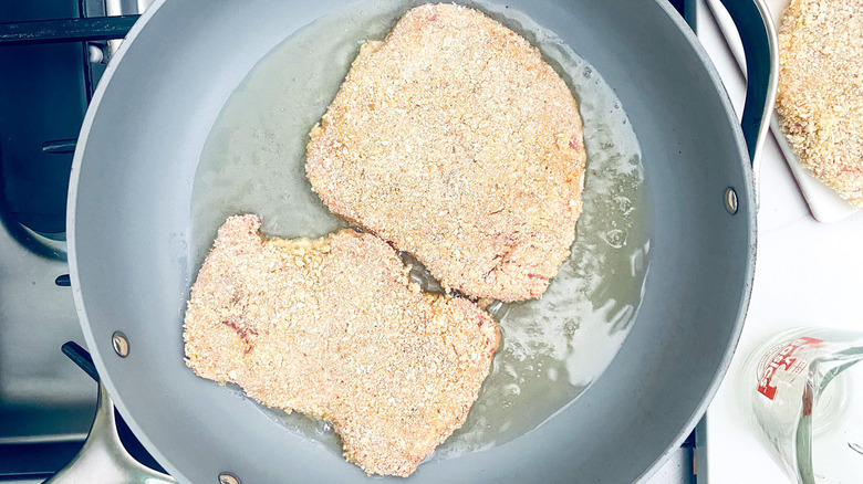 pork cutlets frying in pan