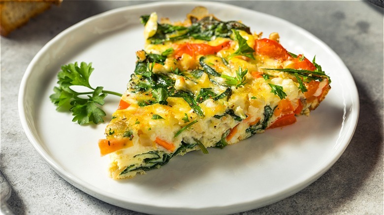 Slice of vegetable frittata on plate