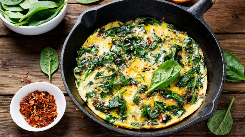 Spinach and eggs with chilis in cast iron skillet