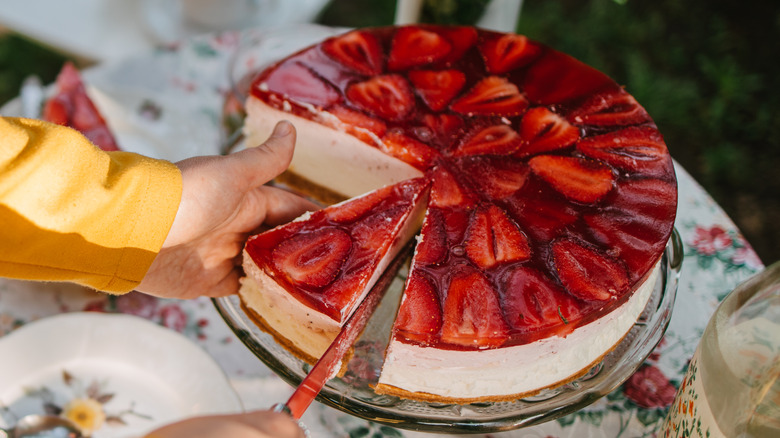 Knife cutting strawberry cheesecake