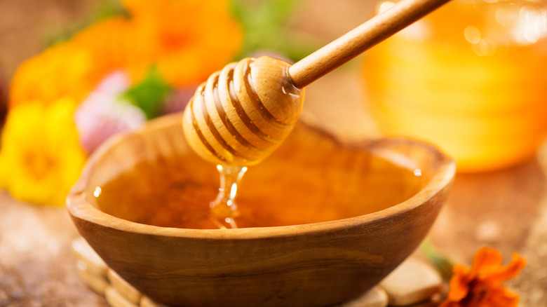 honey being scooped out of a jar 