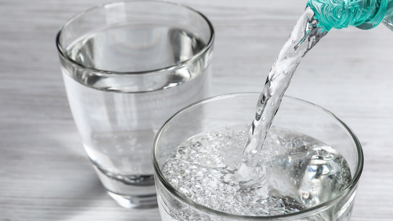 pouring sparkling water into a glass