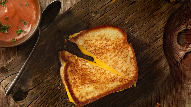 Grilled cheese sandwich cut diagonally on a board