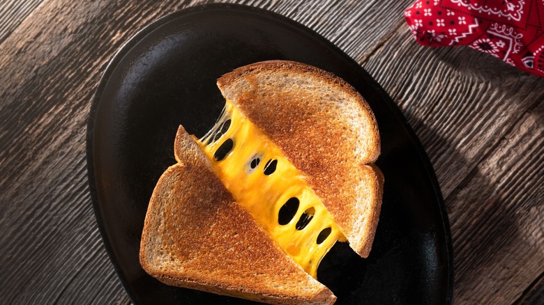 Grilled cheese sandwich pull on a black dish