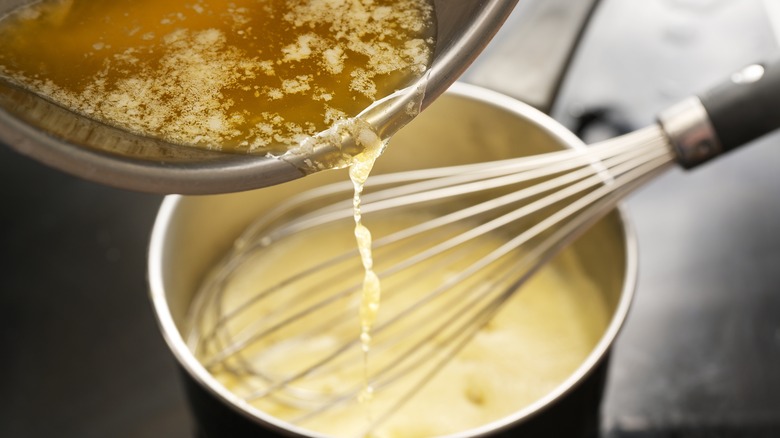 eggs being tempered in a large metal saucepan