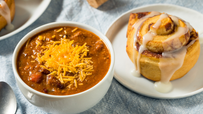 bowl of chili and cinnamon roll on a plate