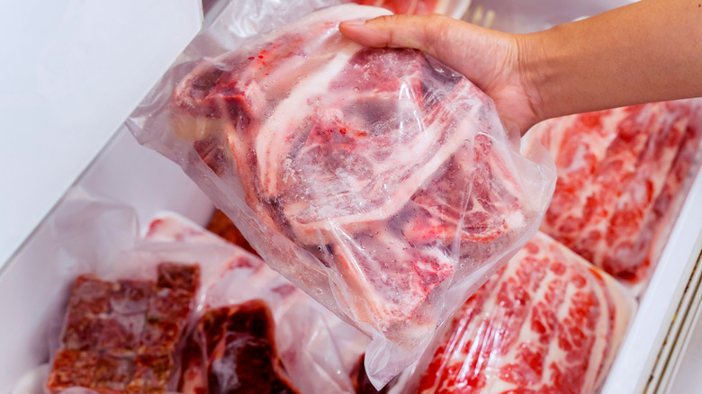 Close-up of hand choosing fresh meat