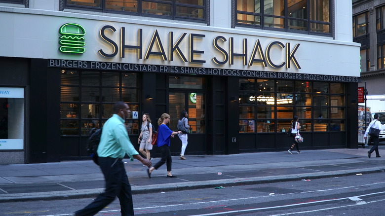 people walking outside a Shake Shack restaurant