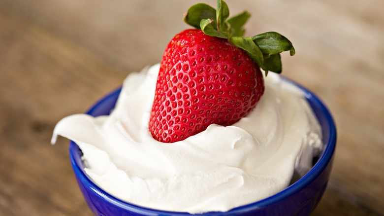 a strawberry with whipped cream