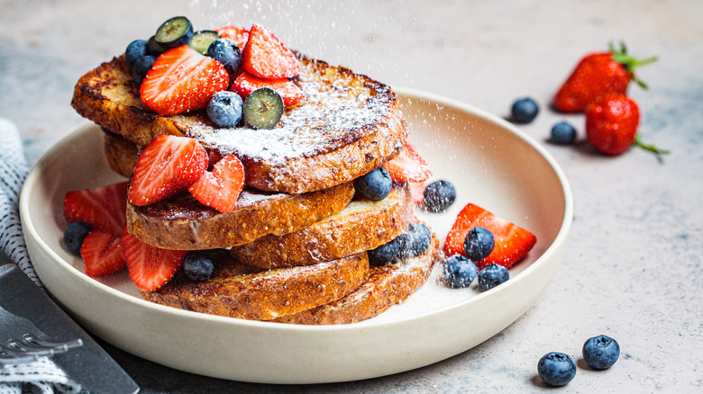 French toast slices stacked and topped with fruit