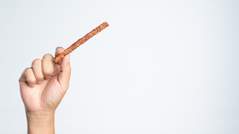 Person holding meat stick