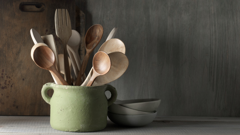 Wooden kitchen utensils in green pot 