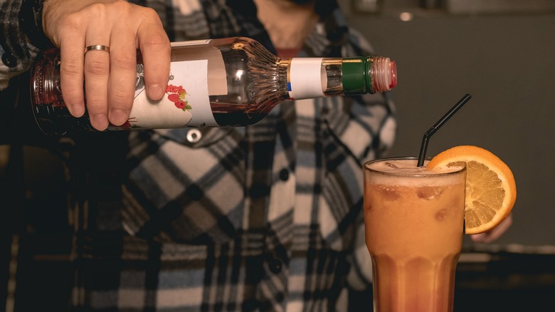 Grenadine pouring into cocktail