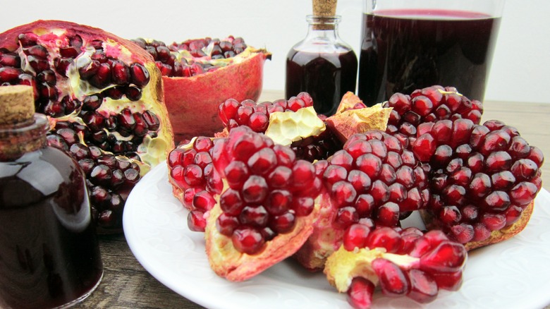 Pomegranate seeds on plate and syrup