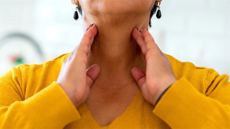 Woman with hands on neck 