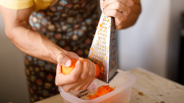 Man grating carrots