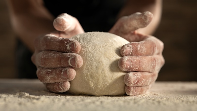 Hands cupping ball of dough