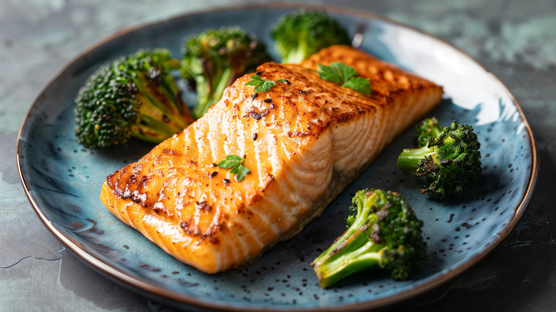 Cooked salmon filet on plate with broccoli