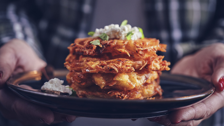 Woman holding a plate of fritters made with canned veggies