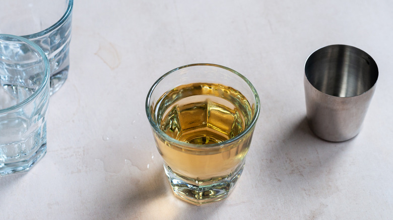 large shot glass surrounded by barware