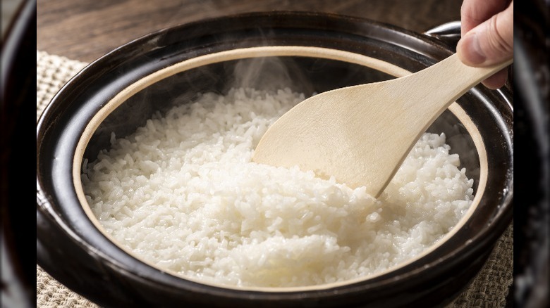 wooden spoon stirring white rice