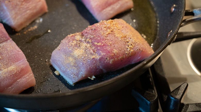 fish fillet cooking in pan