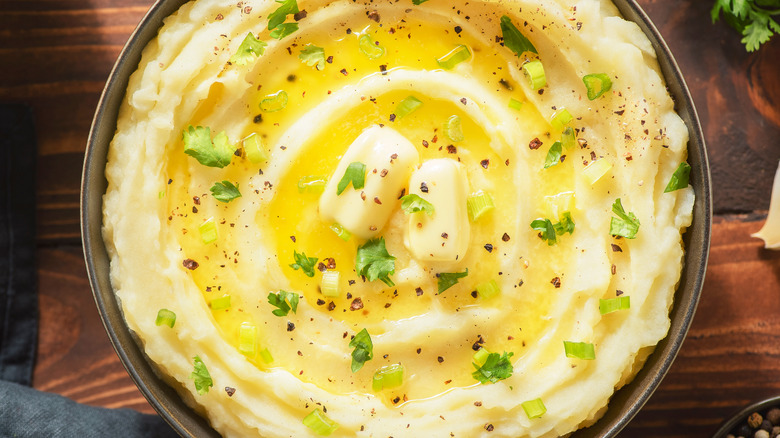 Mashed potatoes with pats of butter on it