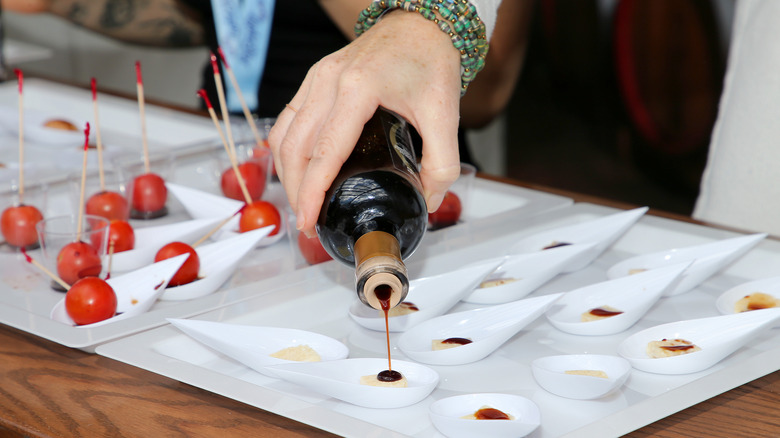 person pouring balsamic vinegar