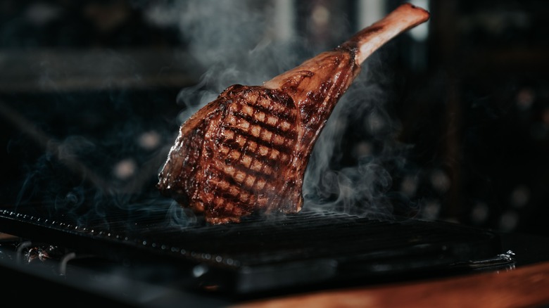 Tomahawk steak on smoky grill