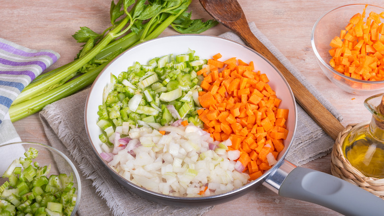 Evenly diced mirepoix ingredients onion, carrot, and celery with olive oil﻿