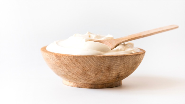 Sour cream in wooden bowl