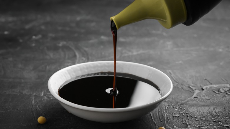 soy sauce being poured from a bottle to a dish