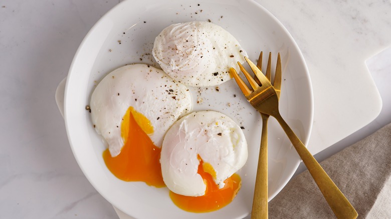 Three poached eggs with forks