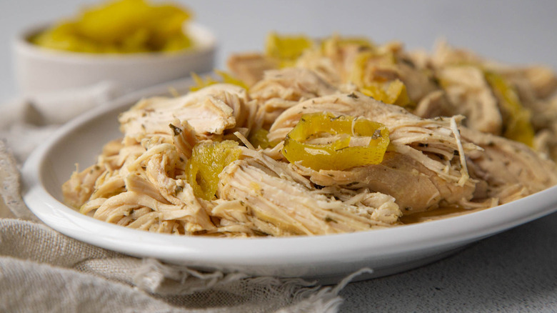 Plate with shredded Mississippi chicken and pepperoncini