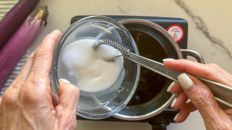 adding slurry to sauce pot